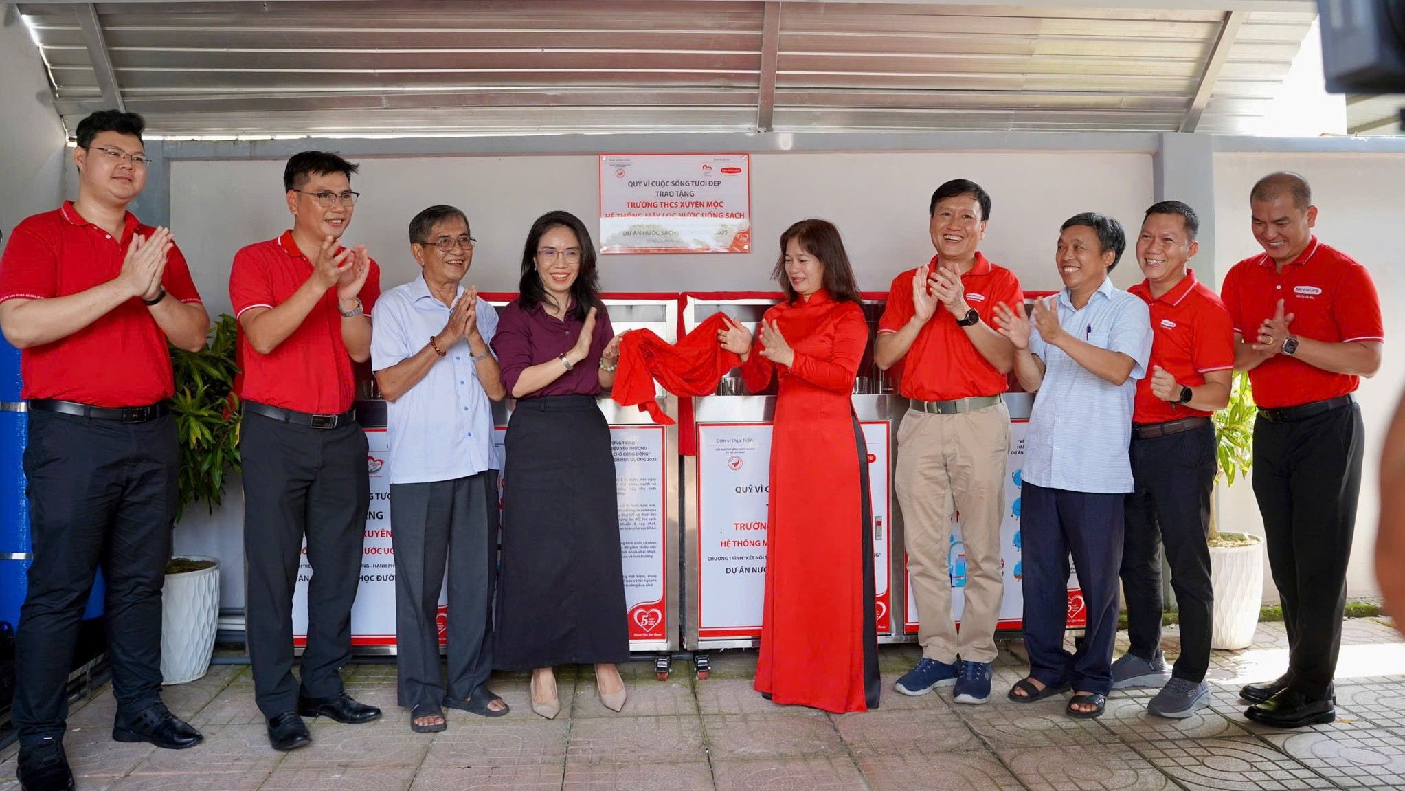 Đại diện Nhà tài trợ, Hội Bảo trợ Bệnh nhân nghèo TP. HCM, Chính quyền địa phương và Ban Giám hiệu nhà trường thực hiện nghi thức bàn giao hệ thống máy lọc nước uống sạch